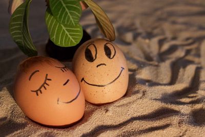 Close-up of ester eggs with smiley face on sandy beach