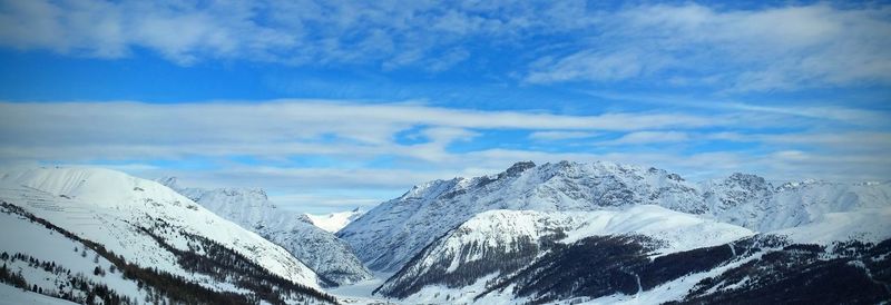 Scenic view of snowcapped mountains against blue sky