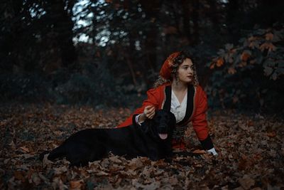 Portrait of young woman with dog on field