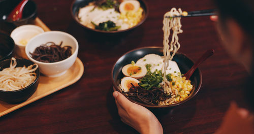 Cropped hand of woman holding food on table