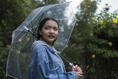 Portrait of woman holding umbrella during rainy season