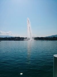 Scenic view of fountain in lake against sky