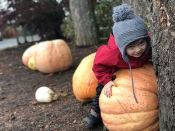 Portrait of smiling boy playing with pumpkins