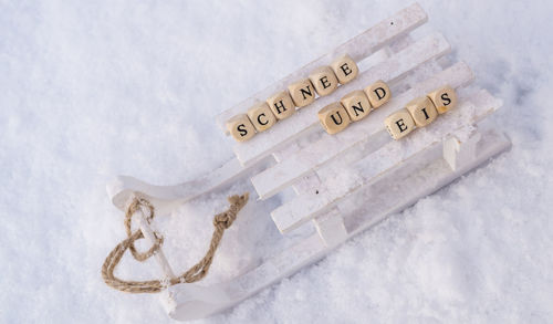 High angle view of toy sledge with text blocks on snow