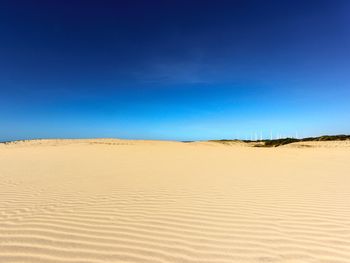 Scenic view of desert against blue sky