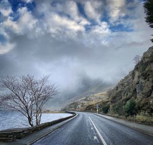 Road amidst trees against sky