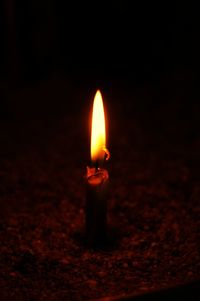 Close-up of lit candle in dark room