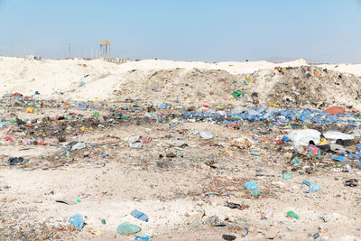 Garbage on sand at beach against sky