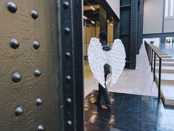 Rear view of man walking on metal door