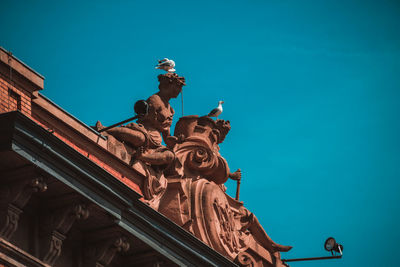 Low angle view of statue against clear blue sky