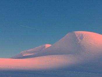 Scenic view of snow mountains against clear blue sky