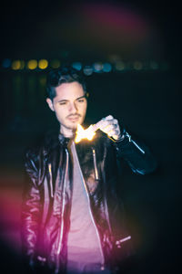 Portrait of young man standing at night