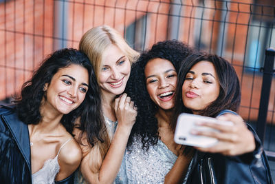 Portrait of smiling young woman using mobile phone