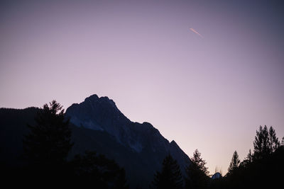 Scenic view of silhouette mountains against clear sky at dusk