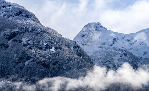 Low angle view of snowcapped mountains against sky