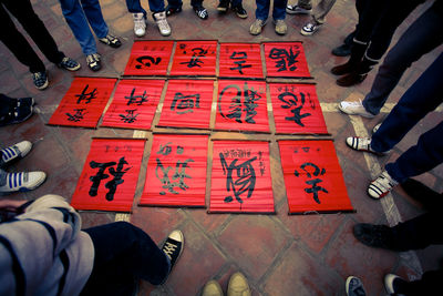 Low section of people standing on tiled floor