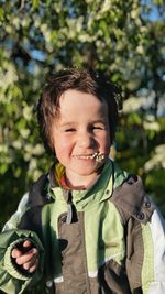 Boy smiling into camera with flowers in his mouth