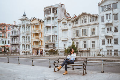 Rear view of woman sitting on street