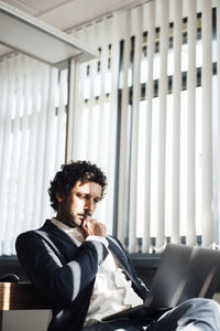 Concentrated businessman using laptop at workplace