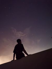 Low angle view of silhouette man standing against sky at night