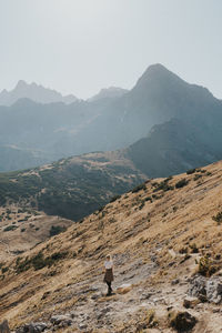 Rear view of man on mountain against sky