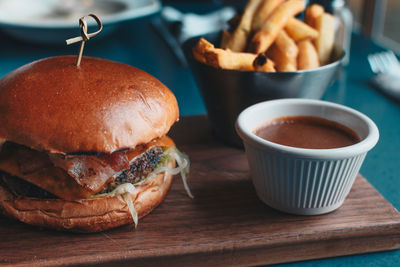 Close-up of burger with dip on cutting board