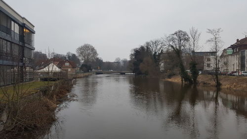 Scenic view of river in city against sky