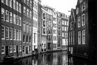 Canal amidst buildings against sky