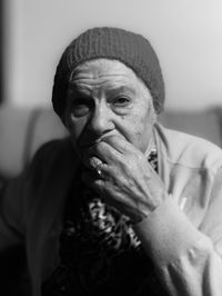 Close-up portrait of senior woman sitting on sofa at home