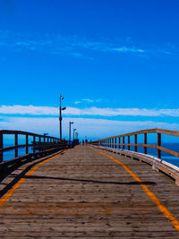 Pier over sea against blue sky