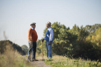 Two old friends standing in the fields, talking about old times