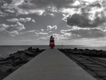 Lighthouse by sea against sky