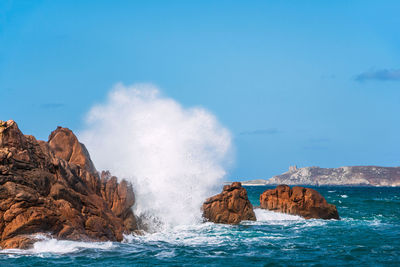 Panoramic view of rocks in sea against blue sky