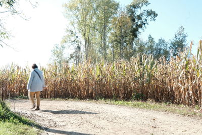 Rear view of woman walking on field