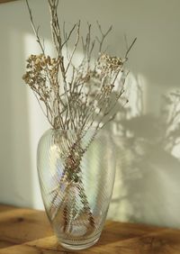 Close-up of vase and dried flowers on table
