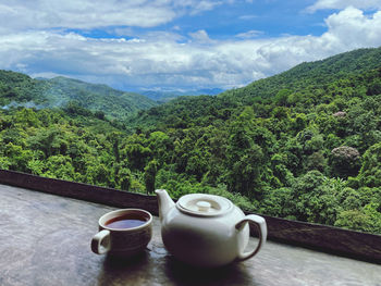 Tea cup on table against mountains