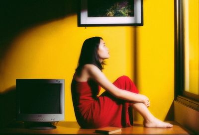Side view of young woman sitting on seat