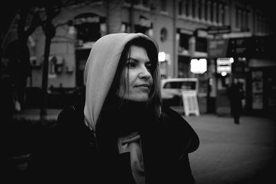 Close-up of young woman on street at night