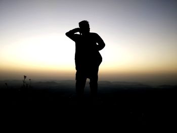 Silhouette man standing against clear sky during sunset