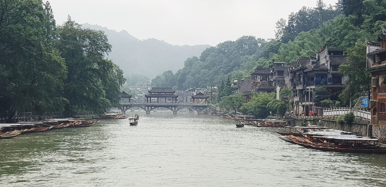 VIEW OF BRIDGE OVER RIVER WITH MOUNTAIN IN BACKGROUND