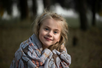 Close-up of cute girl wrapped in blanket