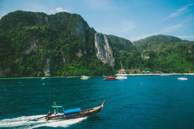 Boats sailing in sea by phi phi island against sky
