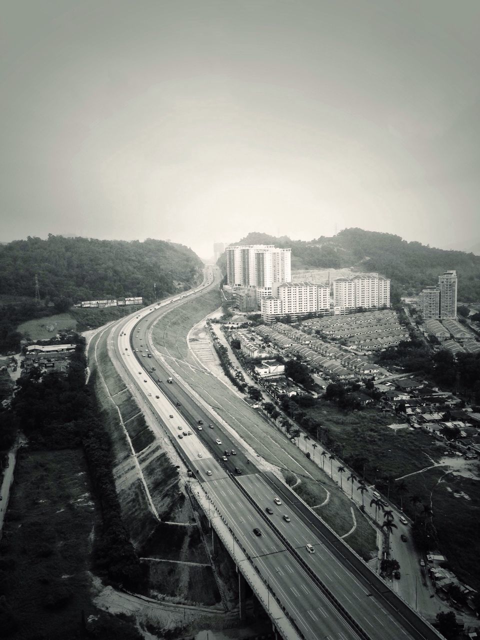 transportation, railroad track, architecture, built structure, high angle view, building exterior, road, rail transportation, clear sky, the way forward, public transportation, city, sky, mode of transport, diminishing perspective, vanishing point, copy space, travel, mountain, outdoors