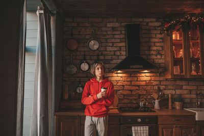 Portrait of candid authentic smiling boy teenager reading book on distance studying at home xmas