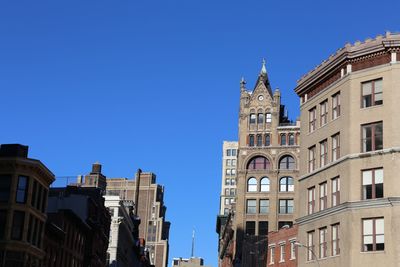 Low angle view of buildings against blue sky