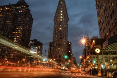 Light trails on road by flatiron building at night