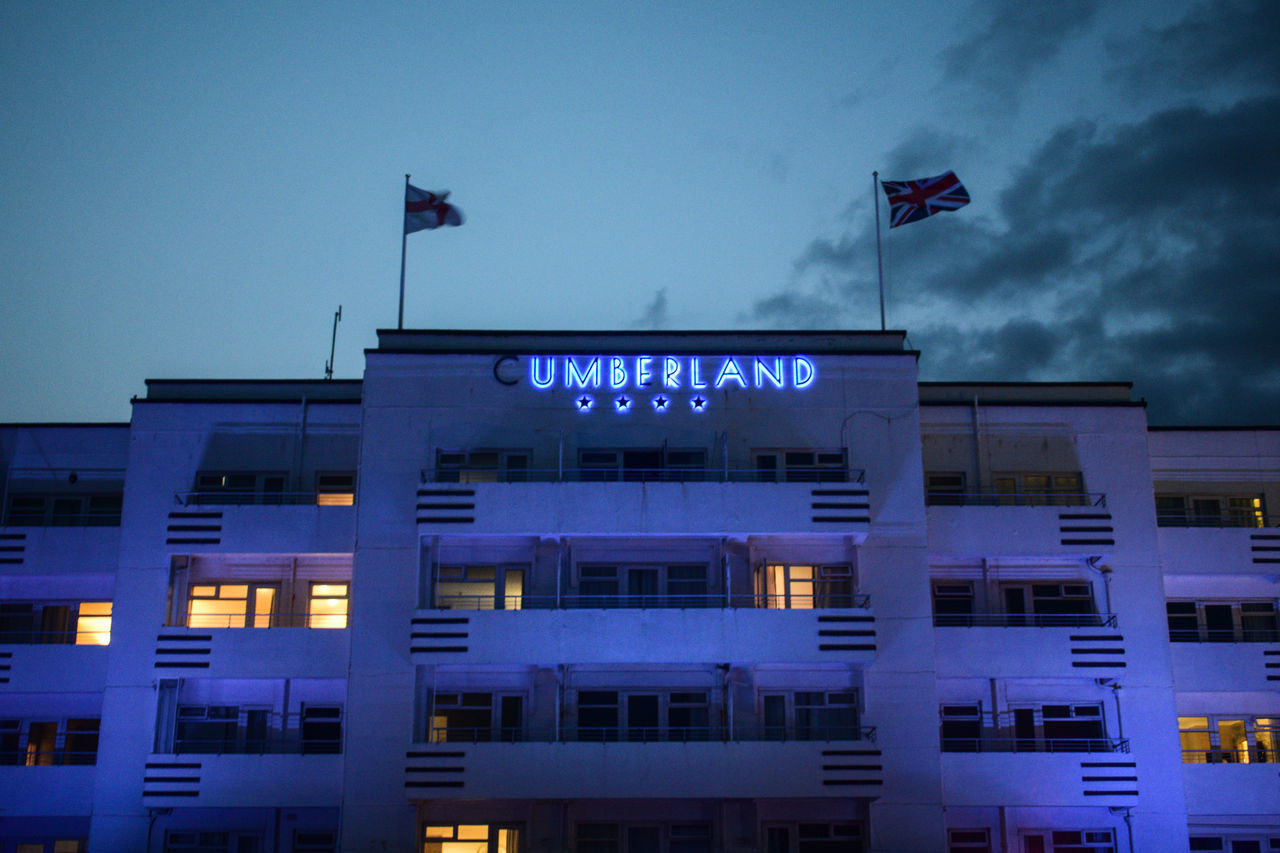 LOW ANGLE VIEW OF ILLUMINATED BUILDING AGAINST BLUE SKY