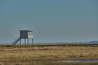 Lifeguard hut on field against clear sky