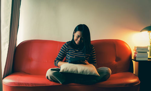 Woman sitting on sofa at home