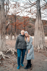 Full length of friends standing by tree